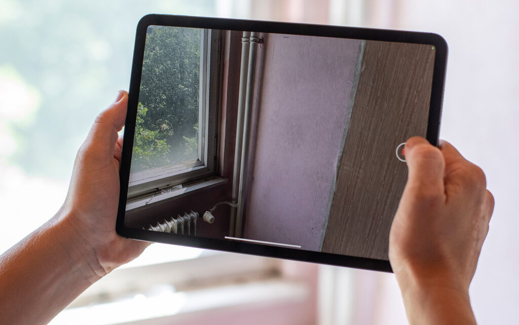 Bestandsaufnahme einer Wohnung mit Tablet für die Planung einer Wohnungsmodernisierung